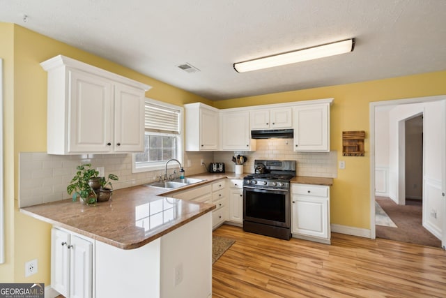 5686 Grindstone Dr, Buford, GA 30518 - kitchen featuring gas range, white cabinets, a peninsula, and light wood-type flooring