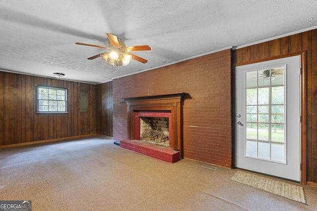 8692 Estes Rd, Macon, GA 31220 - unfurnished living room featuring ceiling fan, a fireplace, carpet floors, wood walls, and a textured ceiling