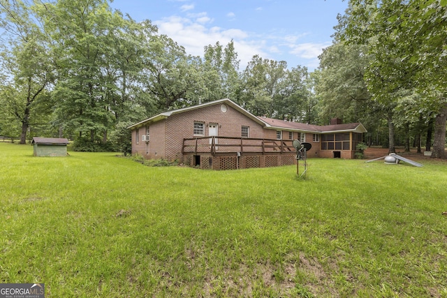 8692 Estes Rd, Macon, GA 31220 - back of property with a deck, brick siding, a lawn, and a sunroom