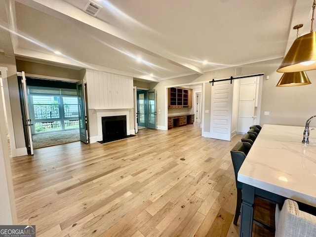 24 Lakewood Park N, Statham, GA 30666 - living area featuring a barn door, light wood finished floors, and a fireplace