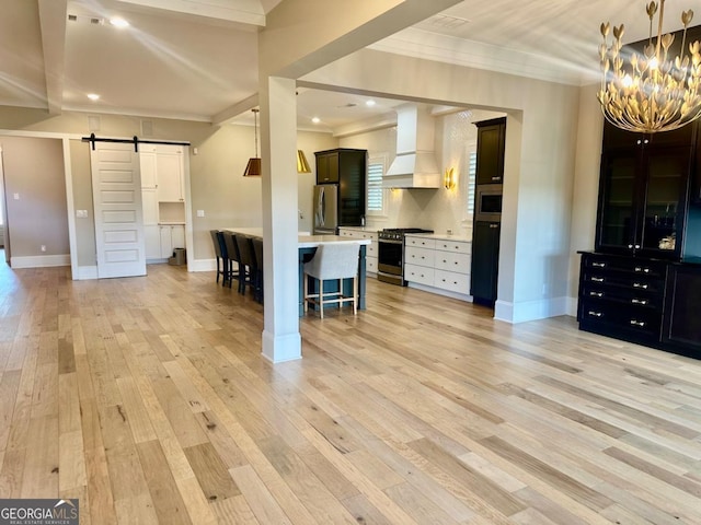 24 Lakewood Park N, Statham, GA 30666 - kitchen featuring custom exhaust hood, a barn door, appliances with stainless steel finishes, a breakfast bar, and crown molding