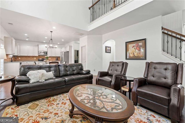 5285 Winflow Way, Suwanee, GA 30024 - living area featuring a chandelier, arched walkways, stairway, recessed lighting, and a high ceiling
