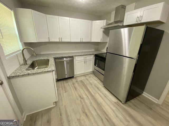 3351 Fox St, Duluth, GA 30096 - kitchen with stainless steel appliances, light wood finished floors, white cabinets, light stone counters, and a textured ceiling