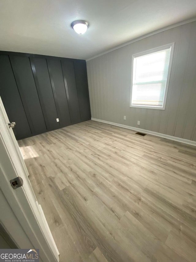 3341 Fox St, Duluth, GA 30096 - empty room with light wood-style floors, ornamental molding, and a decorative wall