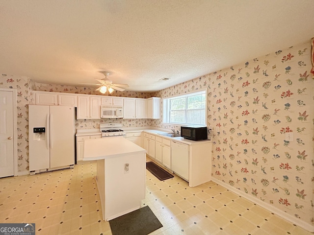 5190 Bankside Way, Peachtree Corners, GA 30092 - kitchen with white appliances, wallpapered walls, a kitchen island, a ceiling fan, and light countertops