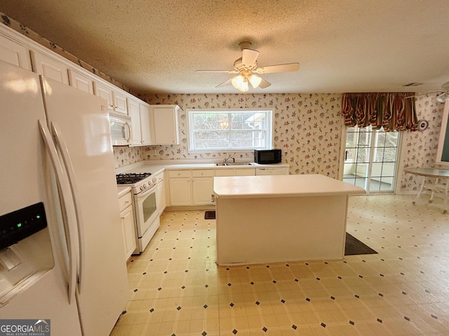 5190 Bankside Way, Peachtree Corners, GA 30092 - kitchen featuring white appliances, wallpapered walls, light flooring, a center island, and light countertops