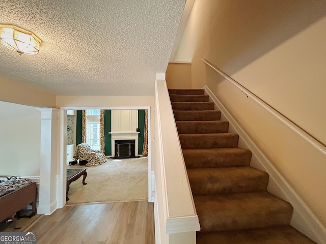 5190 Bankside Way, Peachtree Corners, GA 30092 - stairs with a textured ceiling, wood finished floors, a fireplace, and decorative columns