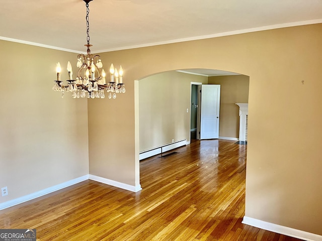 201 Glen Iris Dr, Monroe, GA 30655 - empty room featuring arched walkways, baseboard heating, wood-type flooring, ornamental molding, and a chandelier