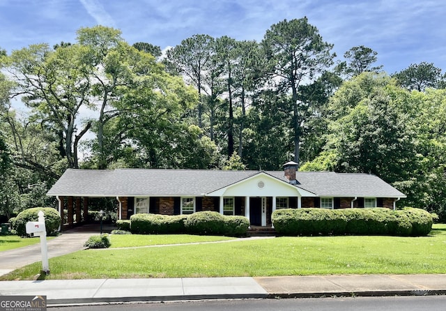 201 Glen Iris Dr, Monroe, GA 30655 - ranch-style home featuring a front yard, concrete driveway, a carport, brick siding, and a chimney