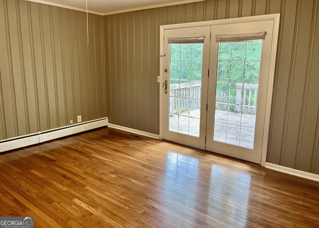 201 Glen Iris Dr, Monroe, GA 30655 - doorway featuring hardwood / wood-style floors, healthy amount of natural light, a baseboard heating unit, ornamental molding, and wood walls