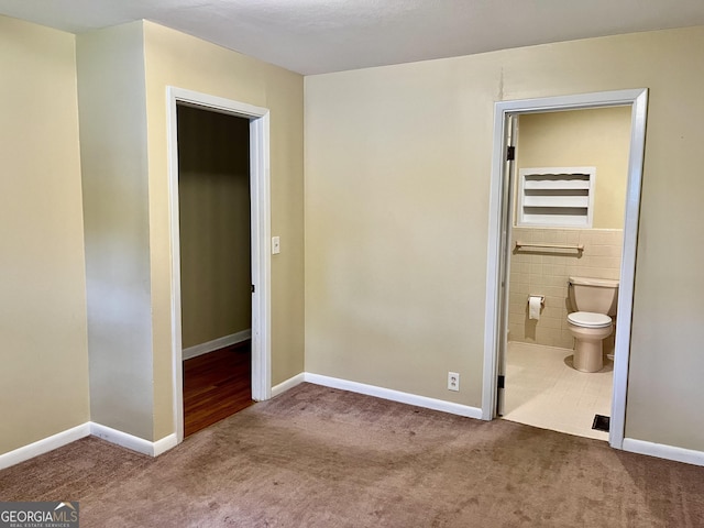 201 Glen Iris Dr, Monroe, GA 30655 - unfurnished bedroom featuring tile walls and carpet floors