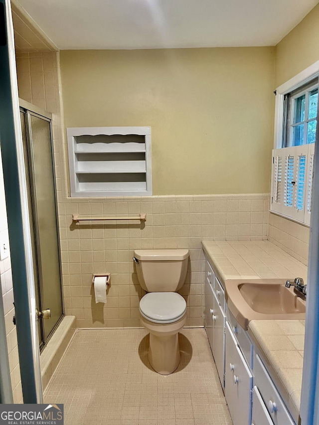 201 Glen Iris Dr, Monroe, GA 30655 - full bath with vanity, a shower stall, tile patterned floors, tile walls, and wainscoting