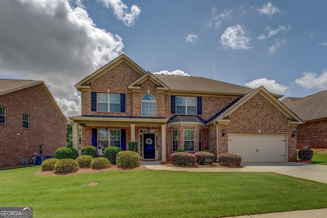 312 Relative Trl, Mcdonough, GA 30253 - view of front of property featuring driveway, brick siding, a front yard, an attached garage, and covered porch