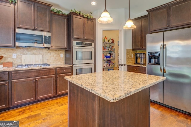 312 Relative Trl, Mcdonough, GA 30253 - kitchen with appliances with stainless steel finishes, light wood-type flooring, light stone counters, decorative backsplash, and decorative light fixtures