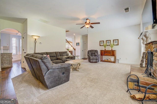 312 Relative Trl, Mcdonough, GA 30253 - living area featuring a ceiling fan, arched walkways, stairs, a stone fireplace, and hardwood / wood-style floors