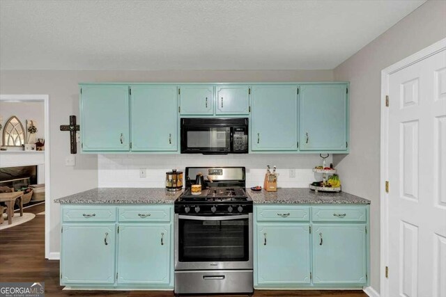 1050 Birdseye Vw, Locust Grove, GA 30248 - kitchen featuring black microwave, stainless steel range with gas cooktop, blue cabinets, backsplash, and dark wood-style flooring