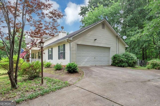 1050 Birdseye Vw, Locust Grove, GA 30248 - view of home's exterior with concrete driveway, an attached garage, and a chimney