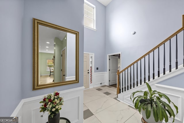 226 Creek View Ln, Acworth, GA 30102 - foyer with healthy amount of natural light, marble finish floors, stairs, a high ceiling, and wainscoting