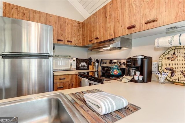 125 Wolfscratch, Big Canoe, GA 30143 - kitchen with appliances with stainless steel finishes, under cabinet range hood, vaulted ceiling, light countertops, and brown cabinetry