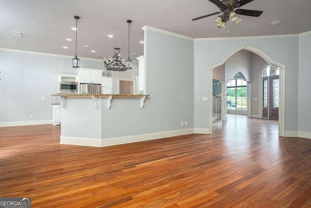 1811 Traditions Way, Jefferson, GA 30549 - unfurnished living room with wood finished floors, arched walkways, a ceiling fan, a chandelier, and recessed lighting