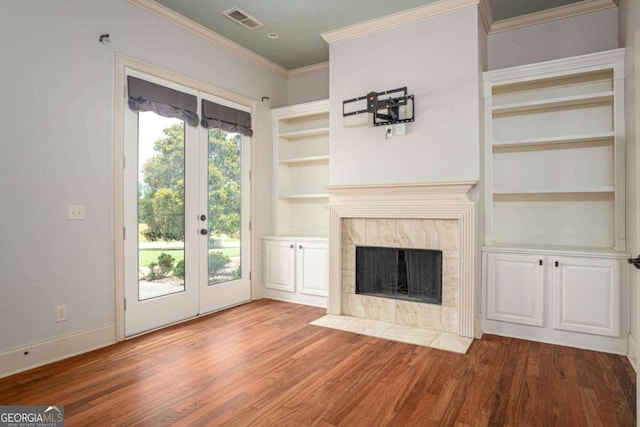 1811 Traditions Way, Jefferson, GA 30549 - unfurnished living room featuring french doors, wood finished floors, built in features, ornamental molding, and a fireplace