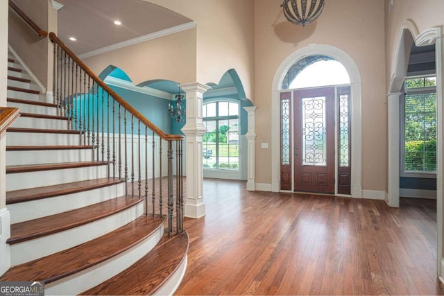 1811 Traditions Way, Jefferson, GA 30549 - foyer featuring wood-type flooring, crown molding, a high ceiling, stairway, and ornate columns