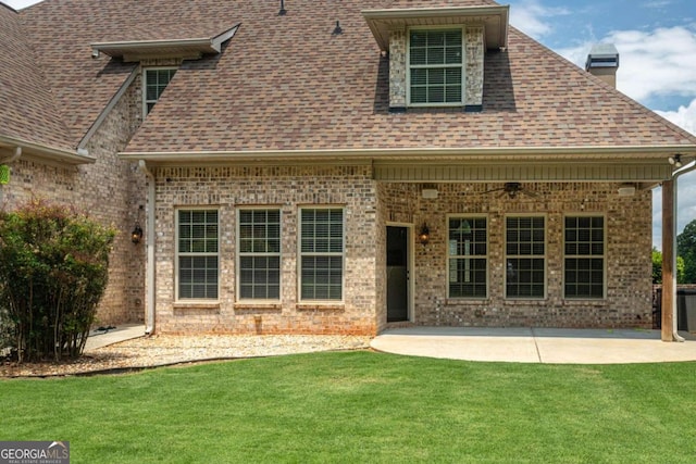 1811 Traditions Way, Jefferson, GA 30549 - rear view of house featuring a shingled roof, a patio, a yard, a chimney, and brick siding