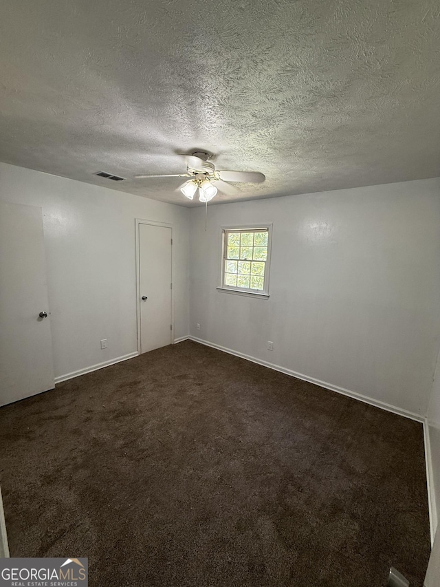 2095 Mulkey Rd SW, Marietta, GA 30008 - empty room featuring a ceiling fan, a textured ceiling, and dark carpet