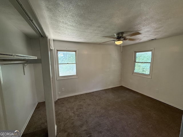 2095 Mulkey Rd SW, Marietta, GA 30008 - unfurnished bedroom with multiple windows, dark carpet, a textured ceiling, and ceiling fan