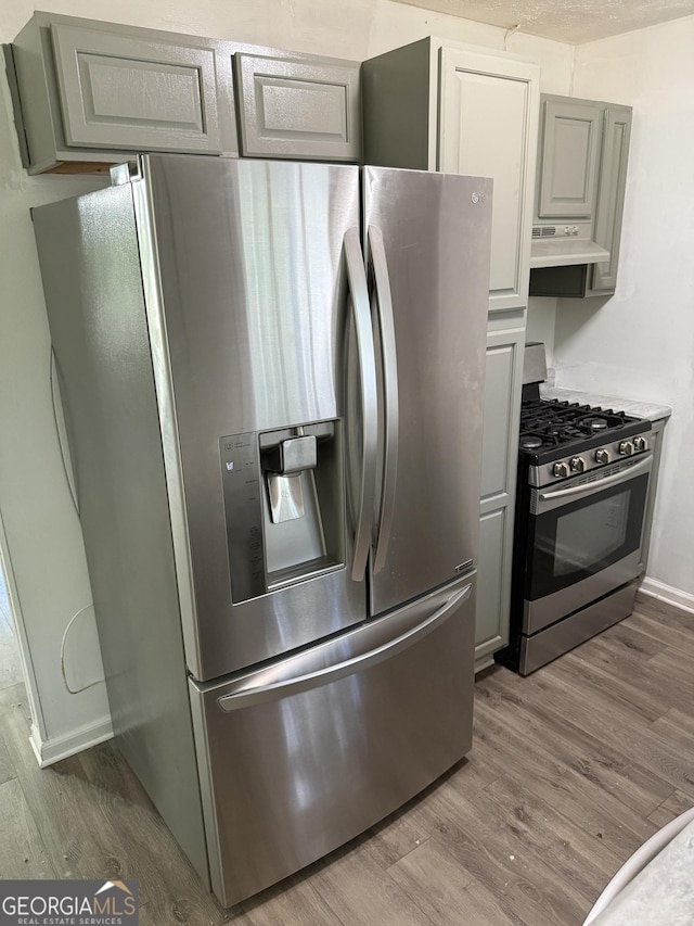 2095 Mulkey Rd SW, Marietta, GA 30008 - kitchen featuring appliances with stainless steel finishes, wood finished floors, and exhaust hood