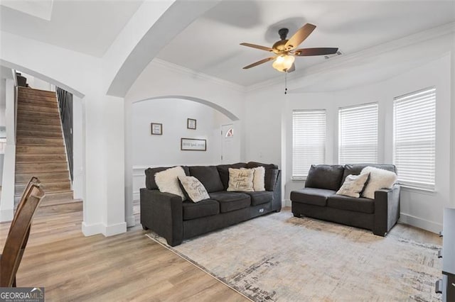 1657 Bradmere Ln, Lithia Springs, GA 30122 - living room with arched walkways, ceiling fan, light wood-style flooring, stairway, and ornamental molding