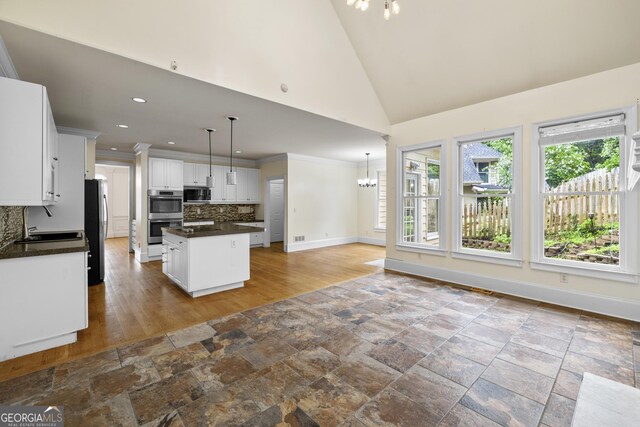 3450 Merganser Ln, Alpharetta, GA 30022 - kitchen with stainless steel appliances, dark countertops, tasteful backsplash, a kitchen island, and white cabinets