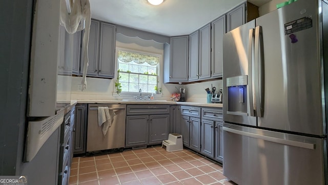 67 Wilder Dr, Forsyth, GA 31029 - kitchen featuring stainless steel appliances, gray cabinetry, light tile patterned floors, and light countertops