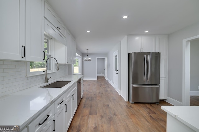 858 Pates Creek Rd, Stockbridge, GA 30281 - kitchen with stainless steel appliances, white cabinetry, decorative backsplash, a chandelier, and light stone countertops