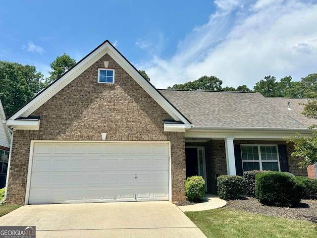 5565 Ashmoore Ct, Flowery Branch, GA 30542 - view of front of home featuring brick siding, concrete driveway, an attached garage, and roof with shingles