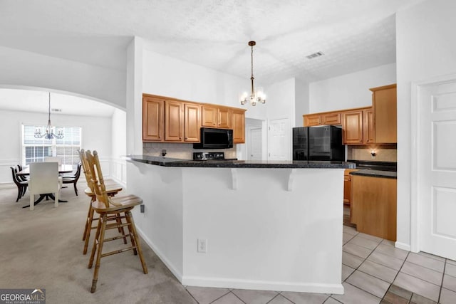 5565 Ashmoore Ct, Flowery Branch, GA 30542 - kitchen featuring a chandelier, black appliances, and a breakfast bar area