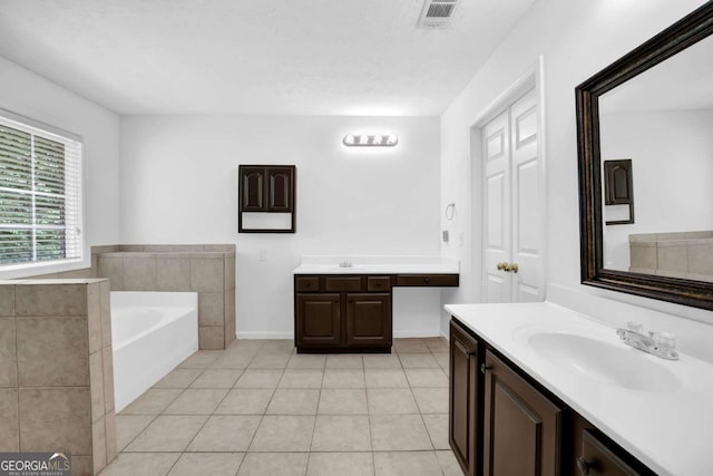 5565 Ashmoore Ct, Flowery Branch, GA 30542 - full bath featuring two vanities, tile patterned floors, and a garden tub