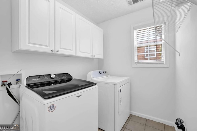 5565 Ashmoore Ct, Flowery Branch, GA 30542 - laundry area with cabinet space, washer and clothes dryer, and light tile patterned floors