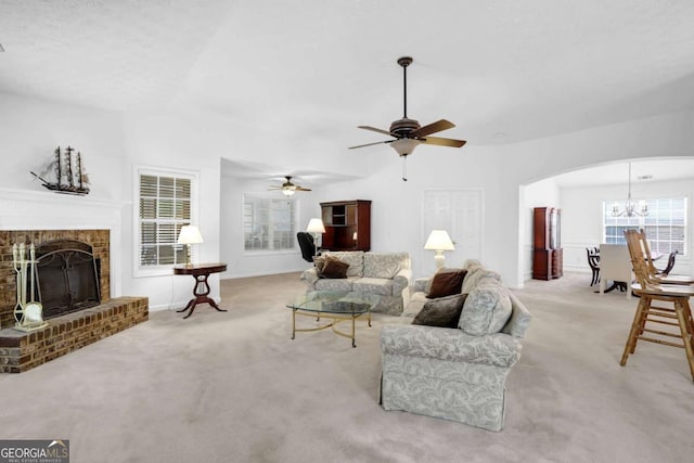 5565 Ashmoore Ct, Flowery Branch, GA 30542 - carpeted living area with arched walkways, ceiling fan, a chandelier, a brick fireplace, and vaulted ceiling