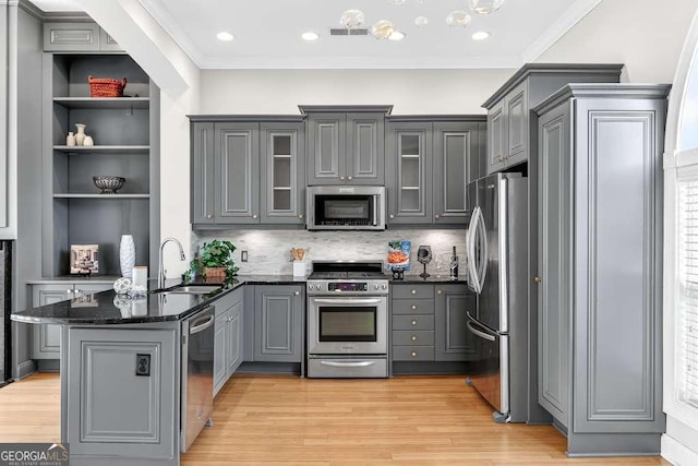 3541 Roswell Rd NE Unit 21, Atlanta, GA 30305 - kitchen with appliances with stainless steel finishes, gray cabinetry, a peninsula, light wood-style flooring, and dark stone countertops
