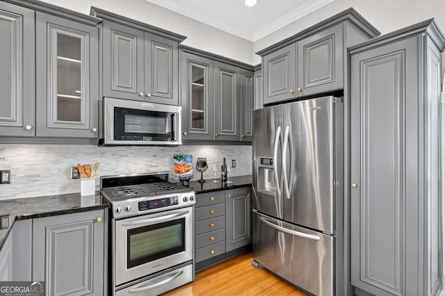 3541 Roswell Rd NE Unit 21, Atlanta, GA 30305 - kitchen with appliances with stainless steel finishes, gray cabinetry, glass insert cabinets, ornamental molding, and dark stone counters
