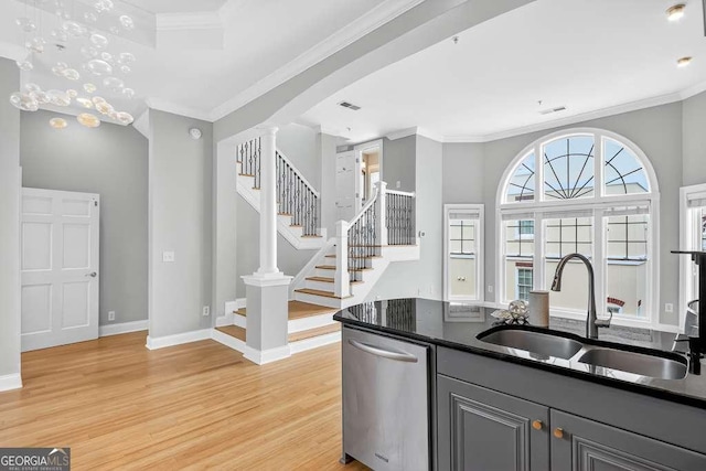 3541 Roswell Rd NE Unit 21, Atlanta, GA 30305 - kitchen with stainless steel dishwasher, light wood finished floors, dark countertops, ornamental molding, and gray cabinets