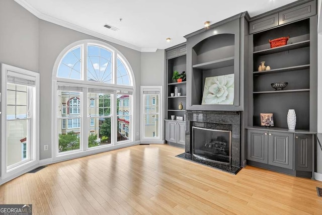 3541 Roswell Rd NE Unit 21, Atlanta, GA 30305 - unfurnished living room featuring crown molding, light wood-style floors, a high end fireplace, and built in features
