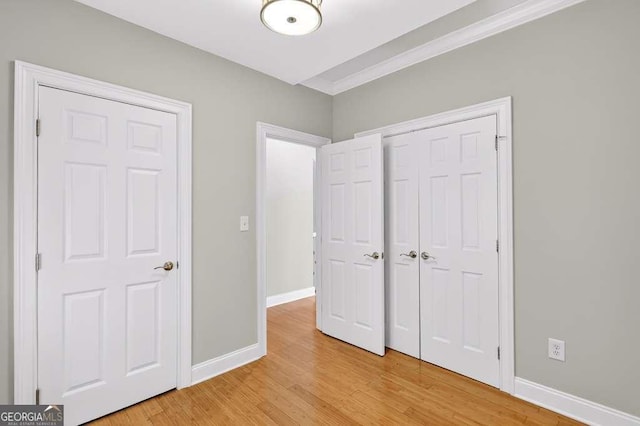 3541 Roswell Rd NE Unit 21, Atlanta, GA 30305 - unfurnished bedroom with light wood-style floors, crown molding, and a closet