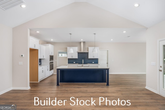 LOT6 The Rock Rd, Thomaston, GA 30286 - kitchen featuring vaulted ceiling, wall chimney exhaust hood, white cabinetry, tasteful backsplash, and light countertops