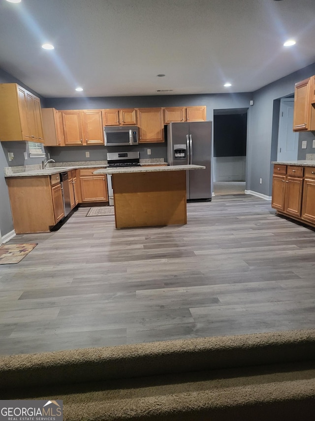 1962 Bridgestone Cir, Conyers, GA 30012 - kitchen with stainless steel appliances, light wood-type flooring, light countertops, a kitchen island, and recessed lighting