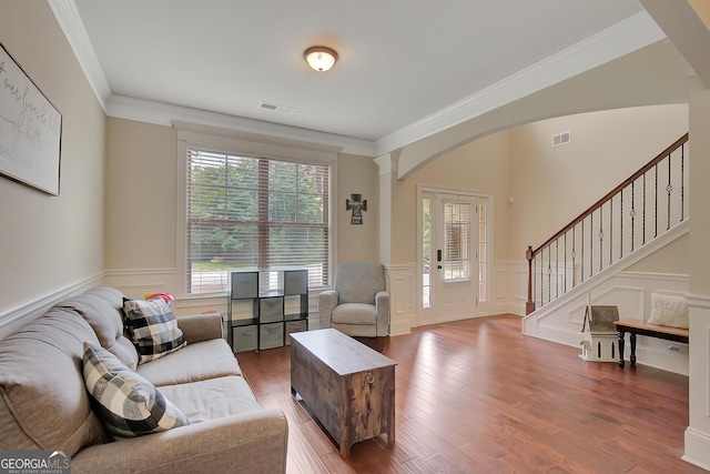 108 Village Pl, Newnan, GA 30265 - living room featuring stairs, a wainscoted wall, ornamental molding, wood finished floors, and arched walkways