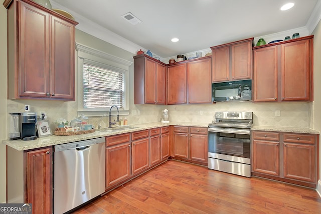 108 Village Pl, Newnan, GA 30265 - kitchen featuring stainless steel appliances, ornamental molding, light wood finished floors, light stone counters, and backsplash