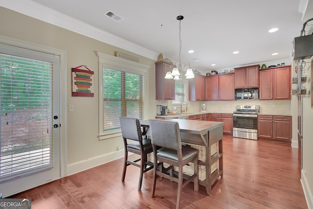108 Village Pl, Newnan, GA 30265 - kitchen featuring stainless steel range oven, ornamental molding, a chandelier, black microwave, and hanging light fixtures