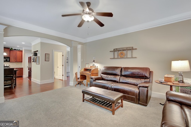 108 Village Pl, Newnan, GA 30265 - living area featuring dark colored carpet, ornate columns, arched walkways, crown molding, and a ceiling fan